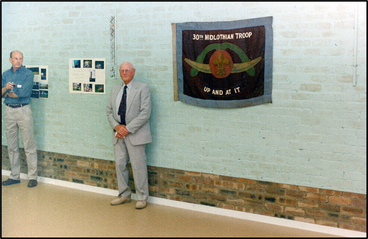 Man standing beside a banner in a hall