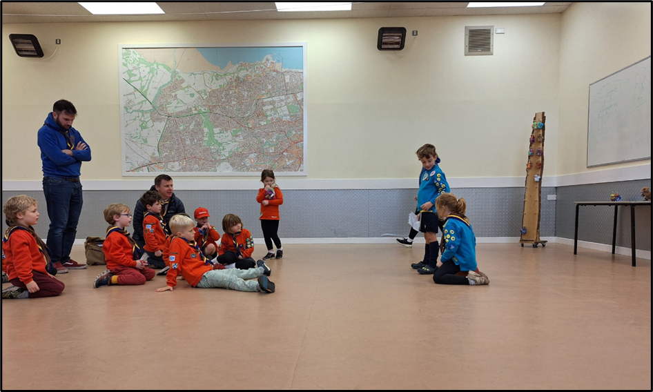 children in red uniforms sitting on a floor