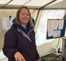 Fiona smiling while cooking sausages