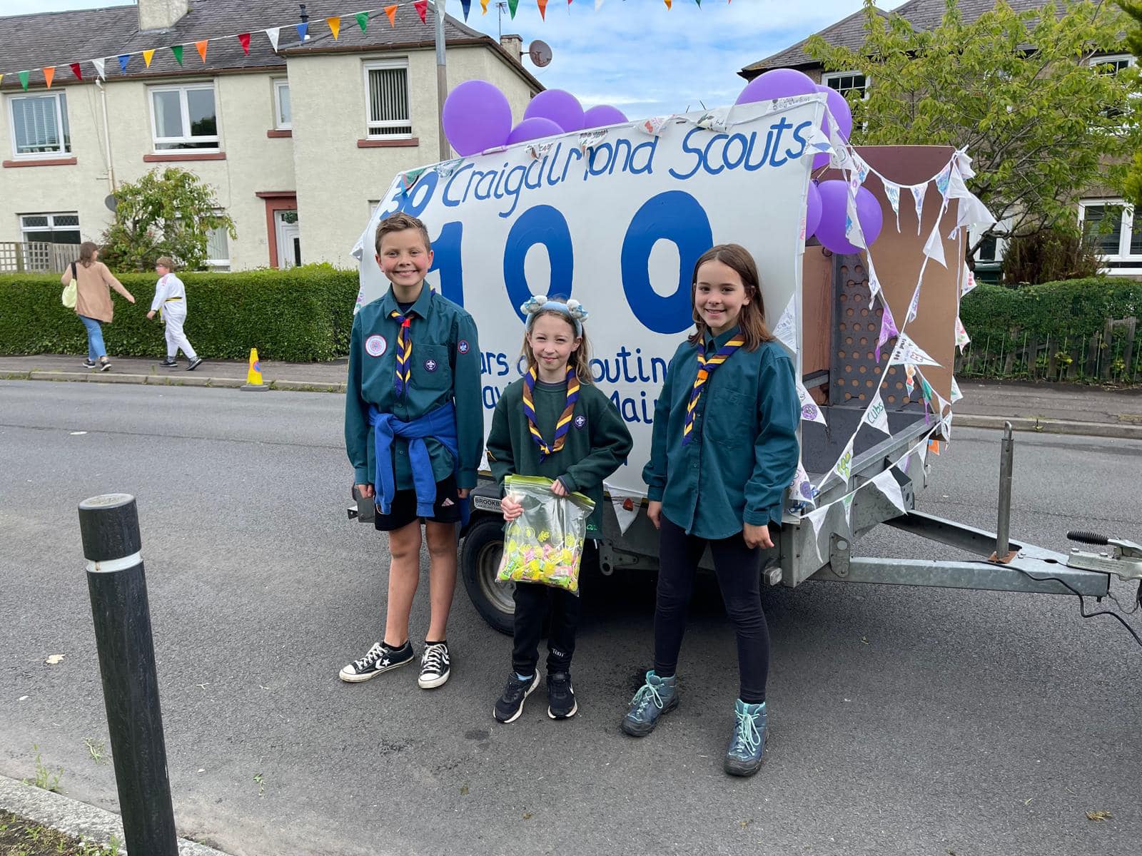 three young people standing in front of a trailer