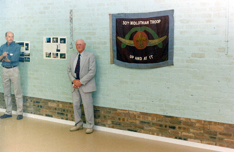 Man standing in hall beside banner on wall