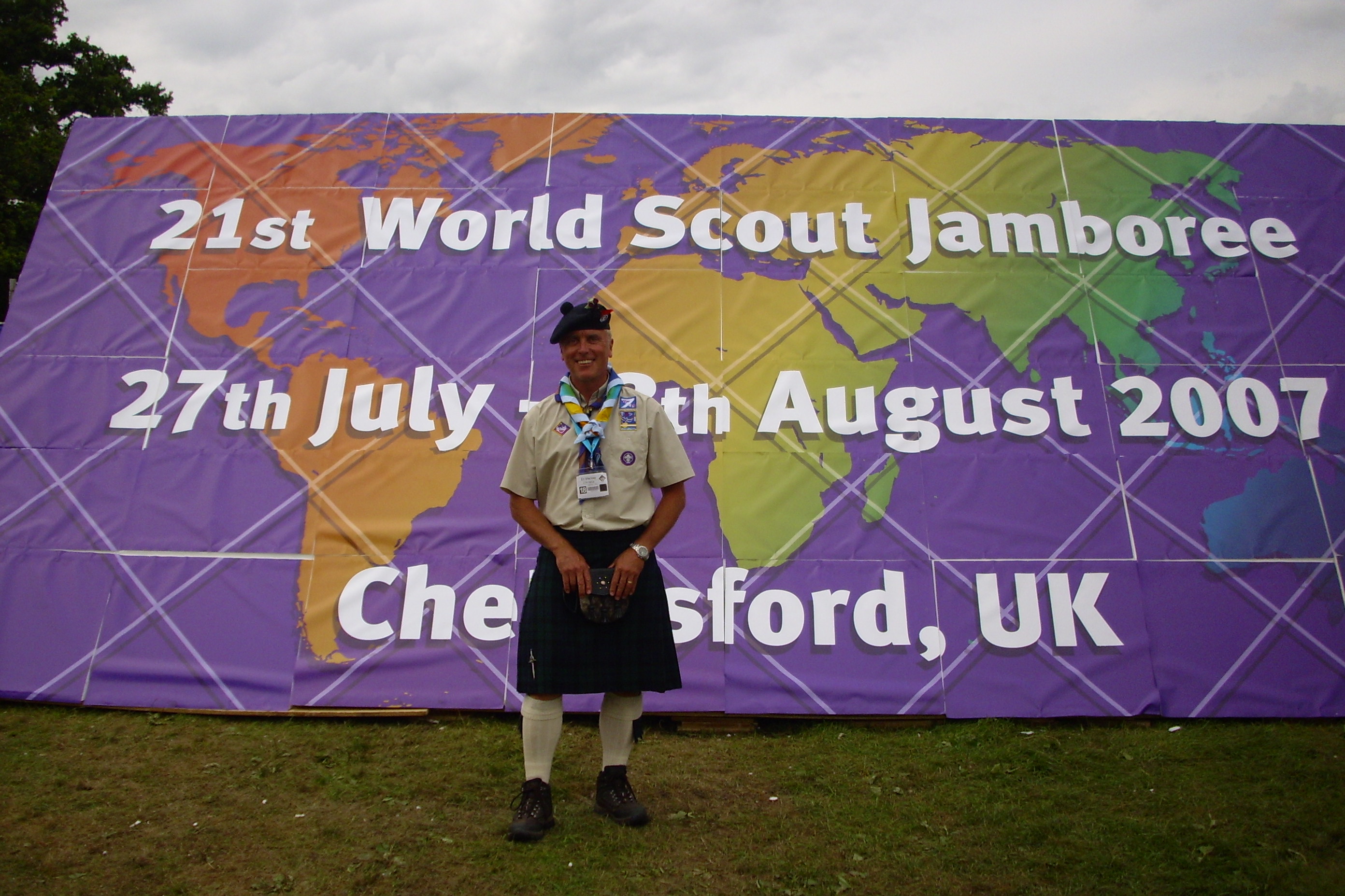 Man in Scout Leader uniform standing in front of banner