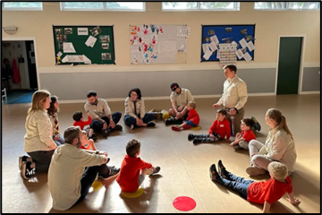Children in red jumpers sitting in a circle
